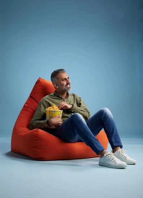 Saudi Man Eating Popcorn on Red Bean Bag Chair Saudi Man Eating Popcorn on Red Bean Bag Chair