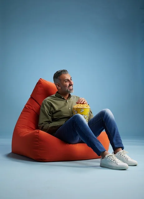 Saudi Man on Red Beanbag Eating Popcorn
