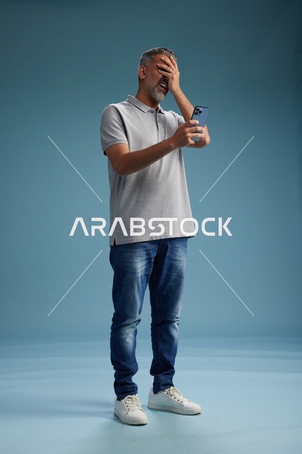 Frustrated Arab Man Using Smartphone in Studio