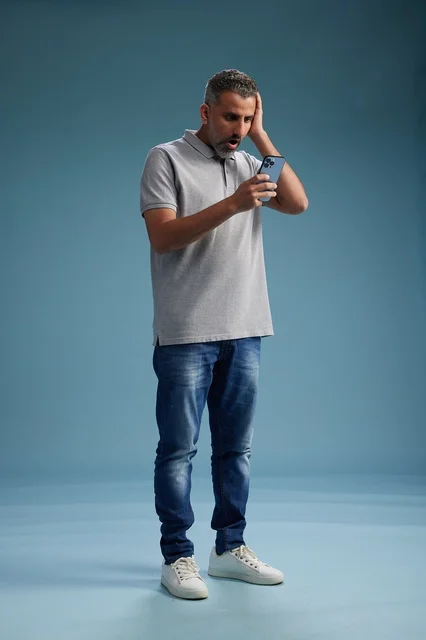 Shocked Arab Man Looking at Smartphone in Studio