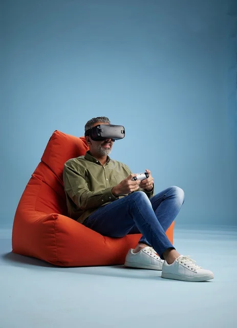رجل يرتدي نظارة واقع افتراضي على كرسي محشو في استوديو