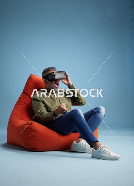 رجل عربي متحمس يرتدي نظارة واقع افتراضي في الاستوديو