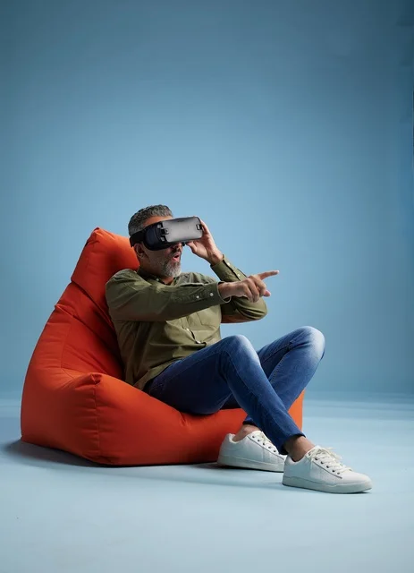 Middle-Aged Man Using VR Headset on Orange Bean Bag