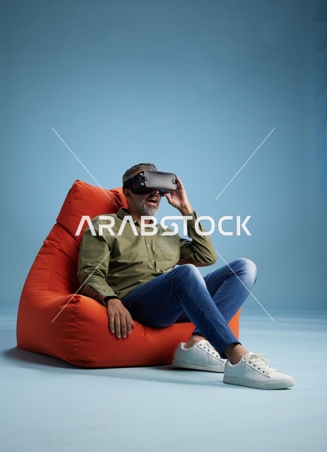 رجل يستخدم سماعة الواقع الافتراضي على خلفية زرقاء