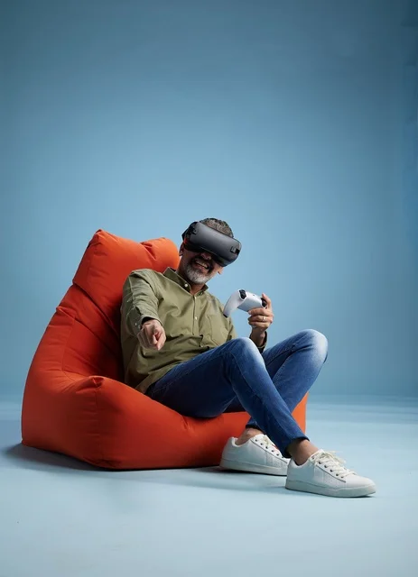 Man Wearing VR Headset on Red Beanbag Chair