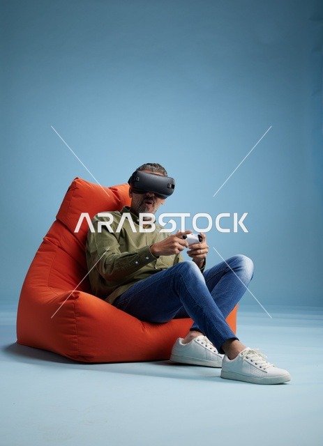 رجل يستخدم سماعة الواقع الافتراضي على كرسي برتقالي