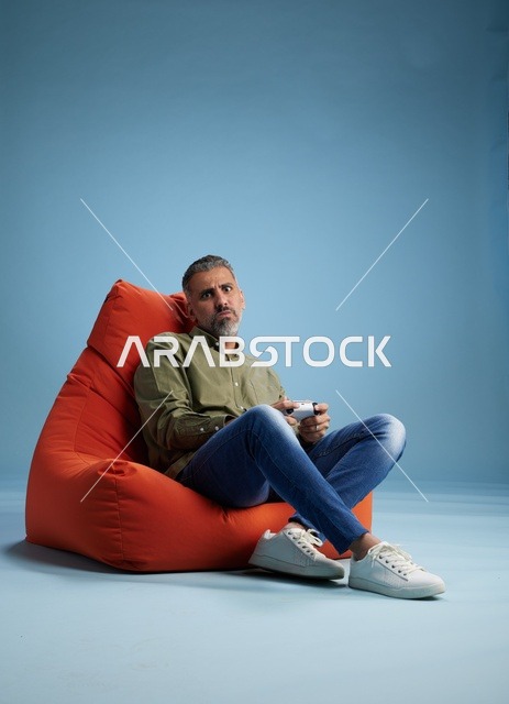 Saudi Man Playing Video Games on Orange Bean Bag