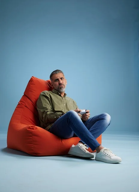 Saudi Man Playing Video Games on Orange Bean Bag
