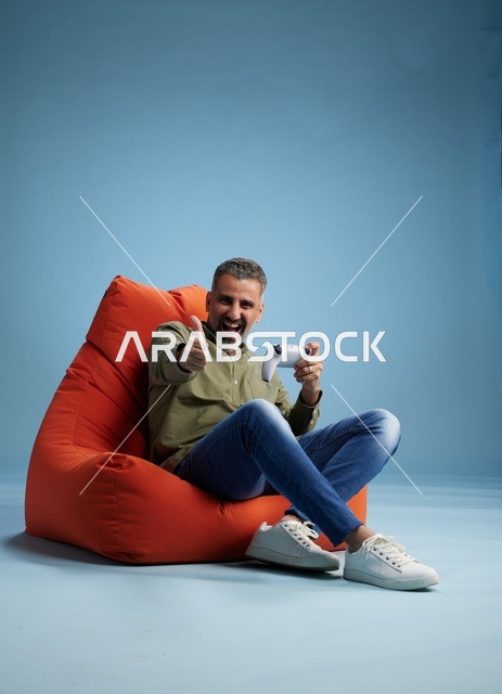 رجل سعودي يلعب ألعاب الفيديو على كنبة كيس