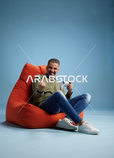 Saudi Man Playing Video Games on Red Bean Bag