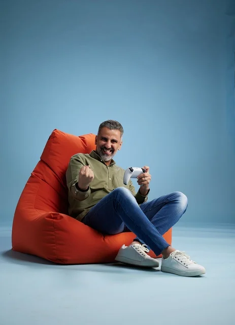 Saudi Man Playing Video Games on Red Bean Bag