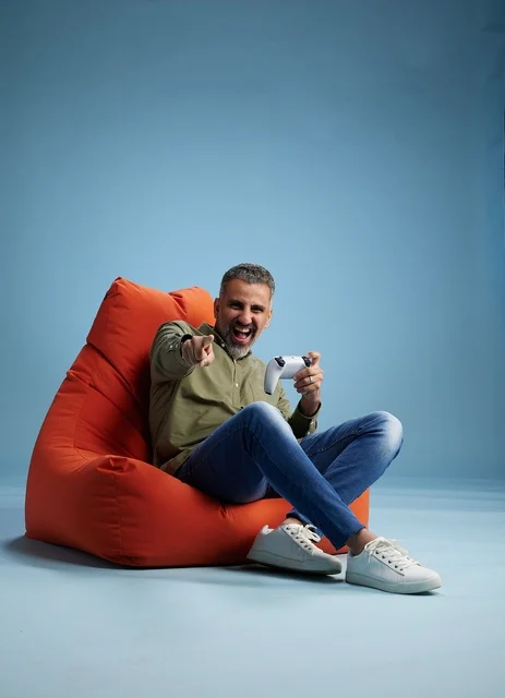 رجل سعودي يلعب ألعاب الفيديو على كنبة كيس