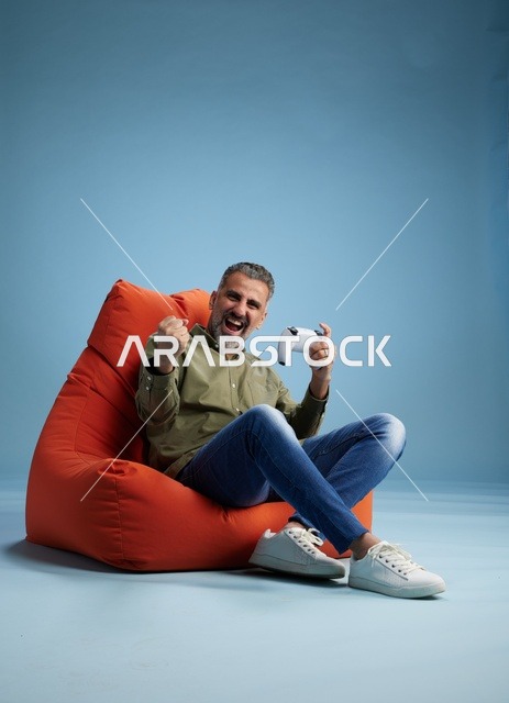 رجل سعودي يلعب ألعاب الفيديو على كنبة كيس