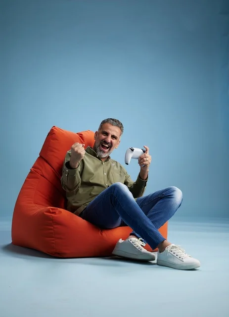 رجل سعودي يلعب ألعاب الفيديو على كنبة كيس