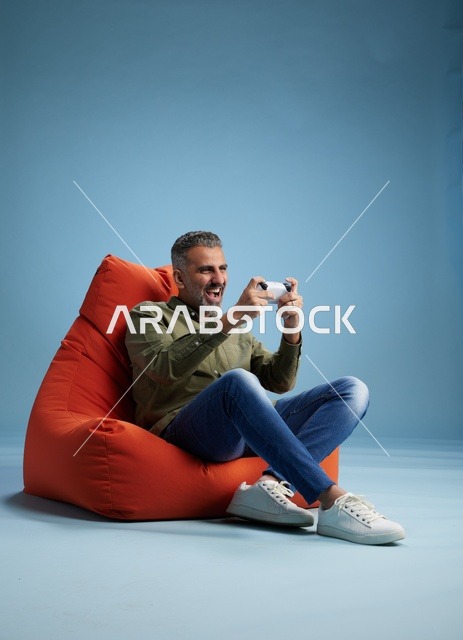 رجل سعودي يلعب ألعاب الفيديو على كنبة كيس
