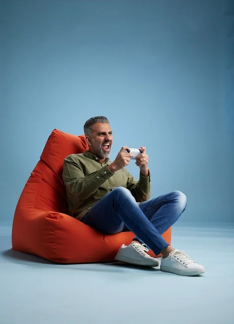 رجل سعودي يلعب ألعاب الفيديو على كنبة كيس