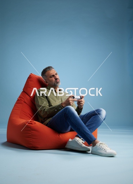 رجل سعودي يلعب ألعاب الفيديو على كنبة كيس