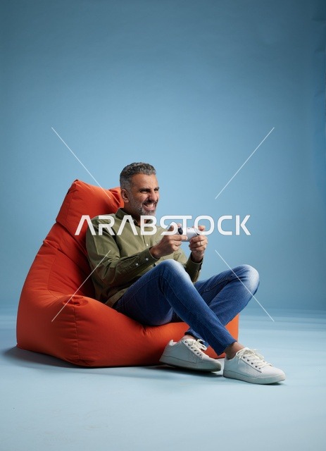 رجل سعودي يلعب ألعاب الفيديو على كنبة كيس