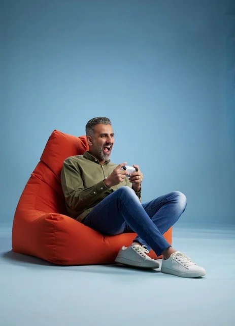 رجل سعودي يلعب ألعاب الفيديو على كنبة كيس