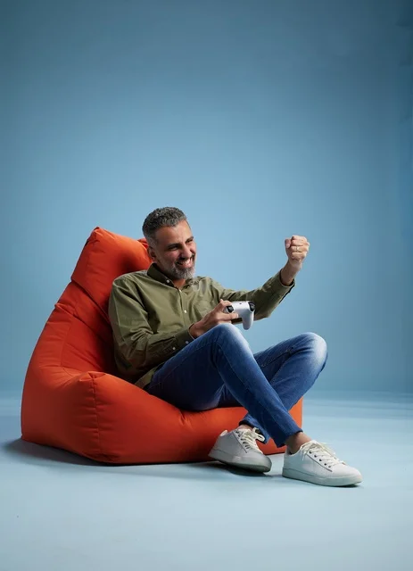 رجل سعودي يلعب ألعاب فيديو على كنبة كيس