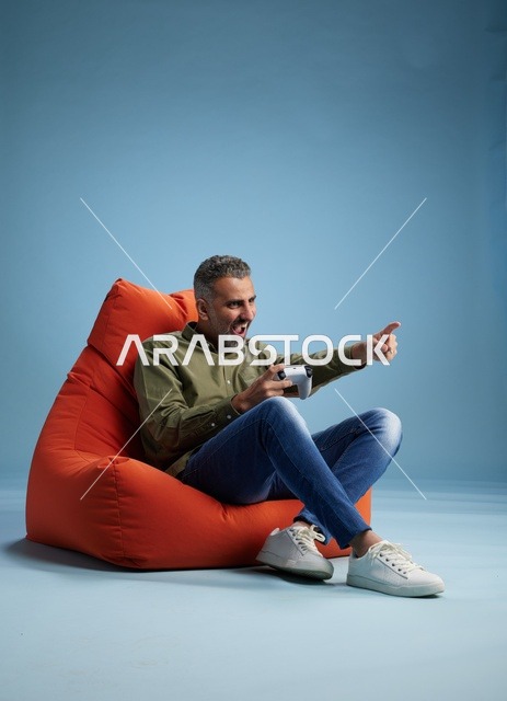 رجل سعودي يلعب ألعاب الفيديو على كنبة كيس