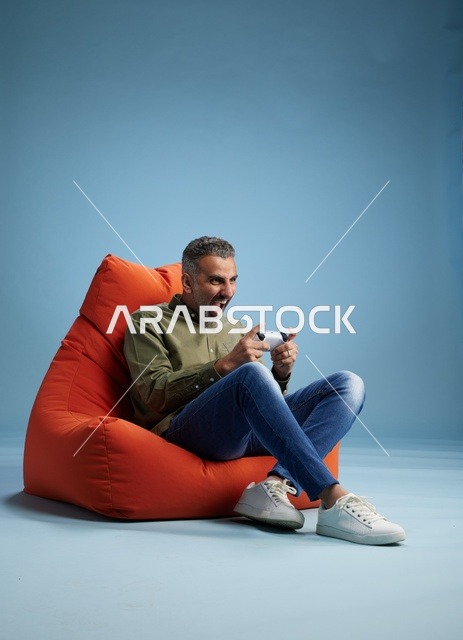 رجل سعودي يلعب ألعاب الفيديو على كنبة كيس