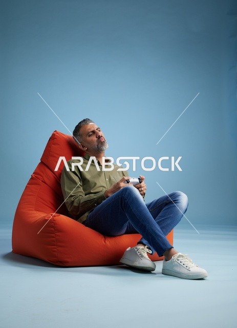 رجل سعودي يلعب ألعاب الفيديو على كنبة كيس