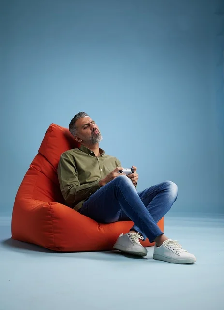 Saudi man playing video games on bean bag chair