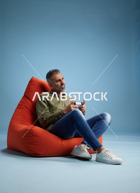 رجل سعودي يلعب ألعاب الفيديو على كنبة كيس