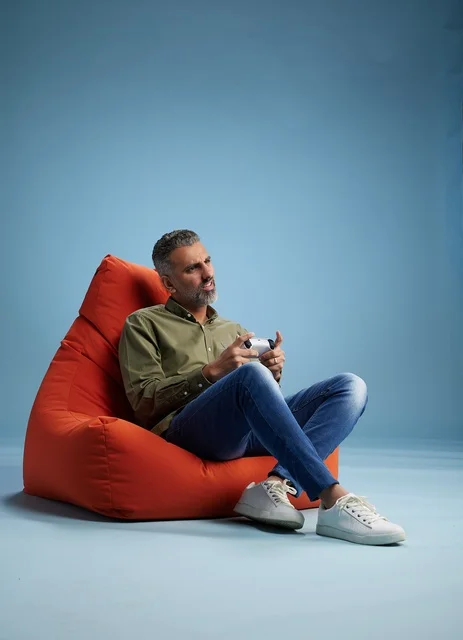 رجل سعودي يلعب ألعاب الفيديو على كنبة كيس