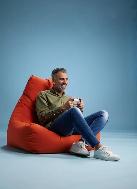 Saudi Man Playing Video Games on Orange Beanbag
