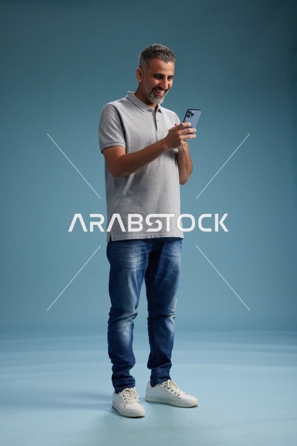 Smiling Saudi Man Using Smartphone in Studio