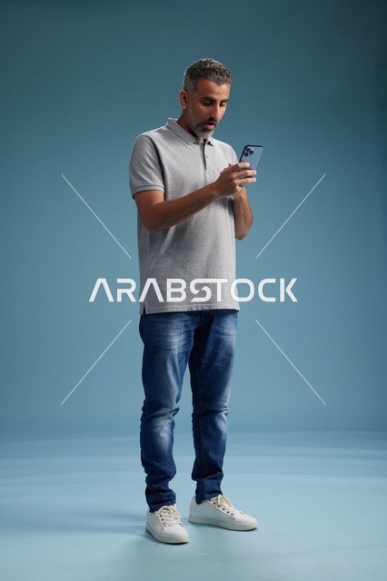 رجل سعودي يستخدم الهاتف الذكي في الاستوديو