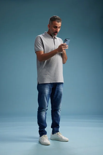 رجل سعودي يستخدم الهاتف الذكي في الاستوديو