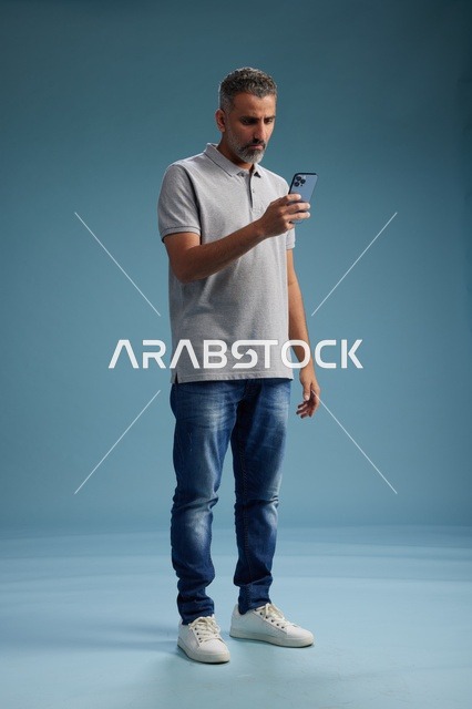 Middle Eastern Man Using Smartphone on Blue Background