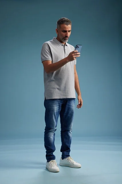 Middle Eastern Man Using Smartphone on Blue Background