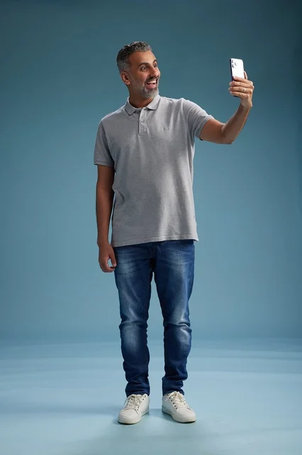 رجل سعودي يلتقط سيلفي في استوديو بخلفية زرقاء