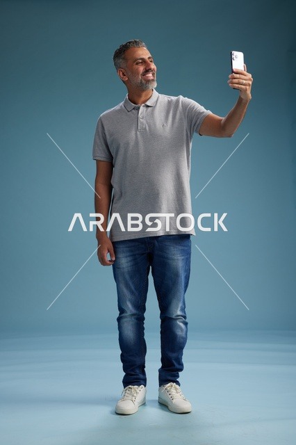 Middle-Aged Arab Man Taking Selfie in Studio