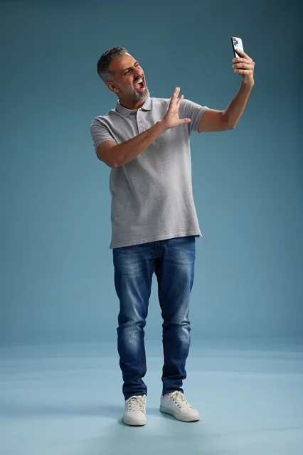 رجل عربي يحمل هاتفا ذكيا ويصرخ في الاستوديو