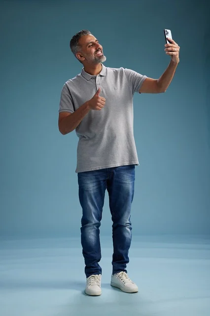 رجل عربي يلتقط صورة سيلفي مع إشارة الإعجاب