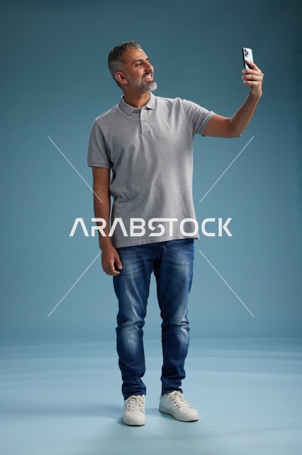 رجل عربي يلتقط سيلفي بالهاتف الذكي في الاستوديو