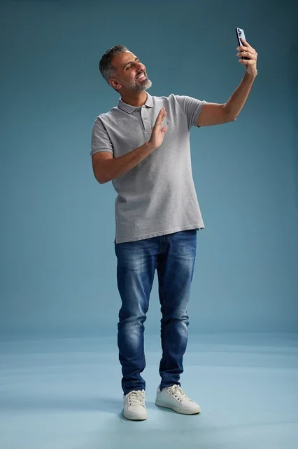 رجل عربي بمنتصف العمر يستخدم الهاتف في استوديو