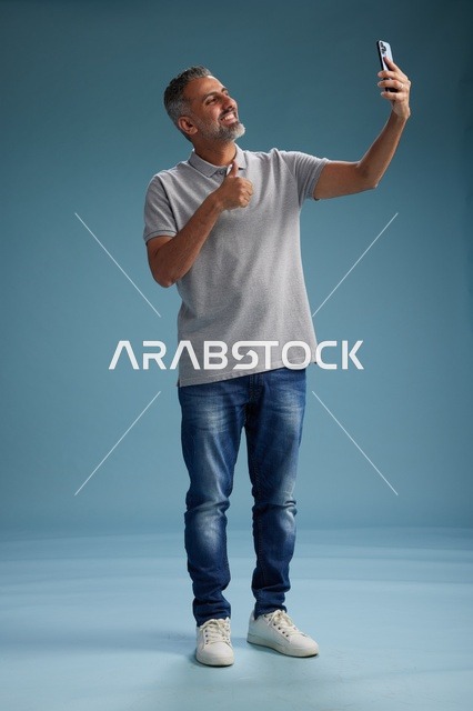 Arab Man Taking Selfie with Thumbs Up in Studio