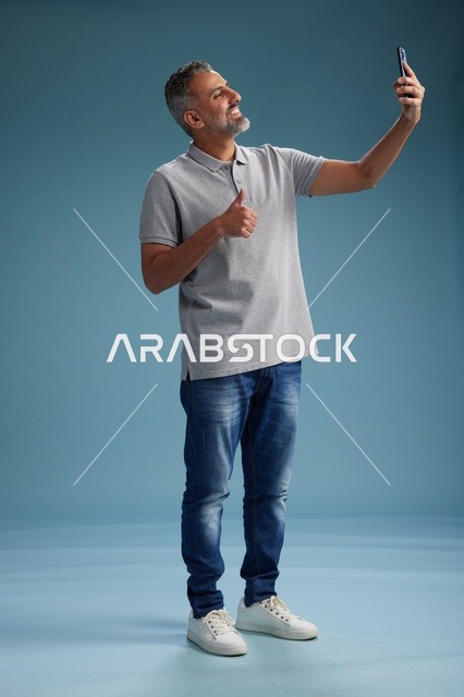 رجل عربي يلتقط سيلفي مع إيماءة الإبهام للأعلى