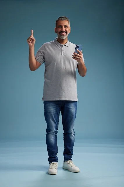 Middle Aged Arab Man Holding Smartphone Pointing Up