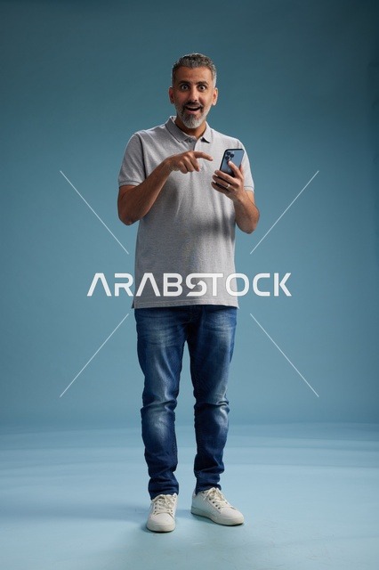 Surprised Arab Man Using Smartphone on Blue Background