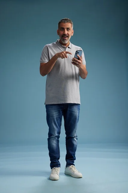 Surprised Arab Man Using Smartphone on Blue Background