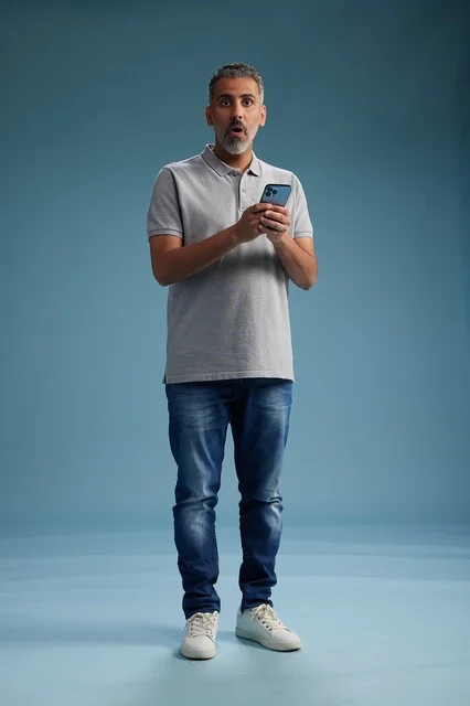 Arab Man With Shocked Expression Holding Smartphone