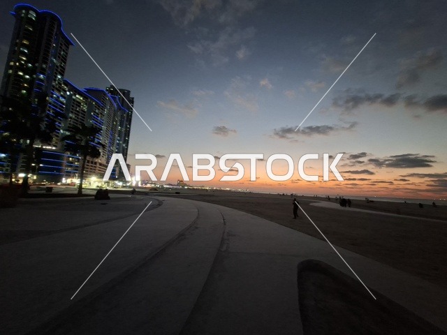 غروب الشمس على الشاطئ مع ناطحات السحاب الحديثة