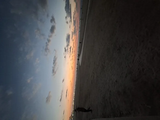 Sunset Over Wide Sandy Beach at Twilight with Clouds